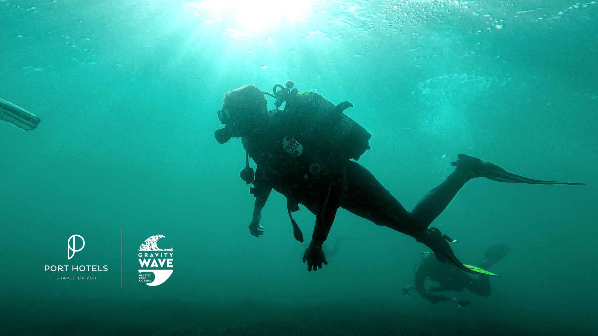 un hombre bucea en el océano junto a un cartel que dice gravity wave