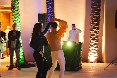 a man and a woman are dancing in front of a dj - 