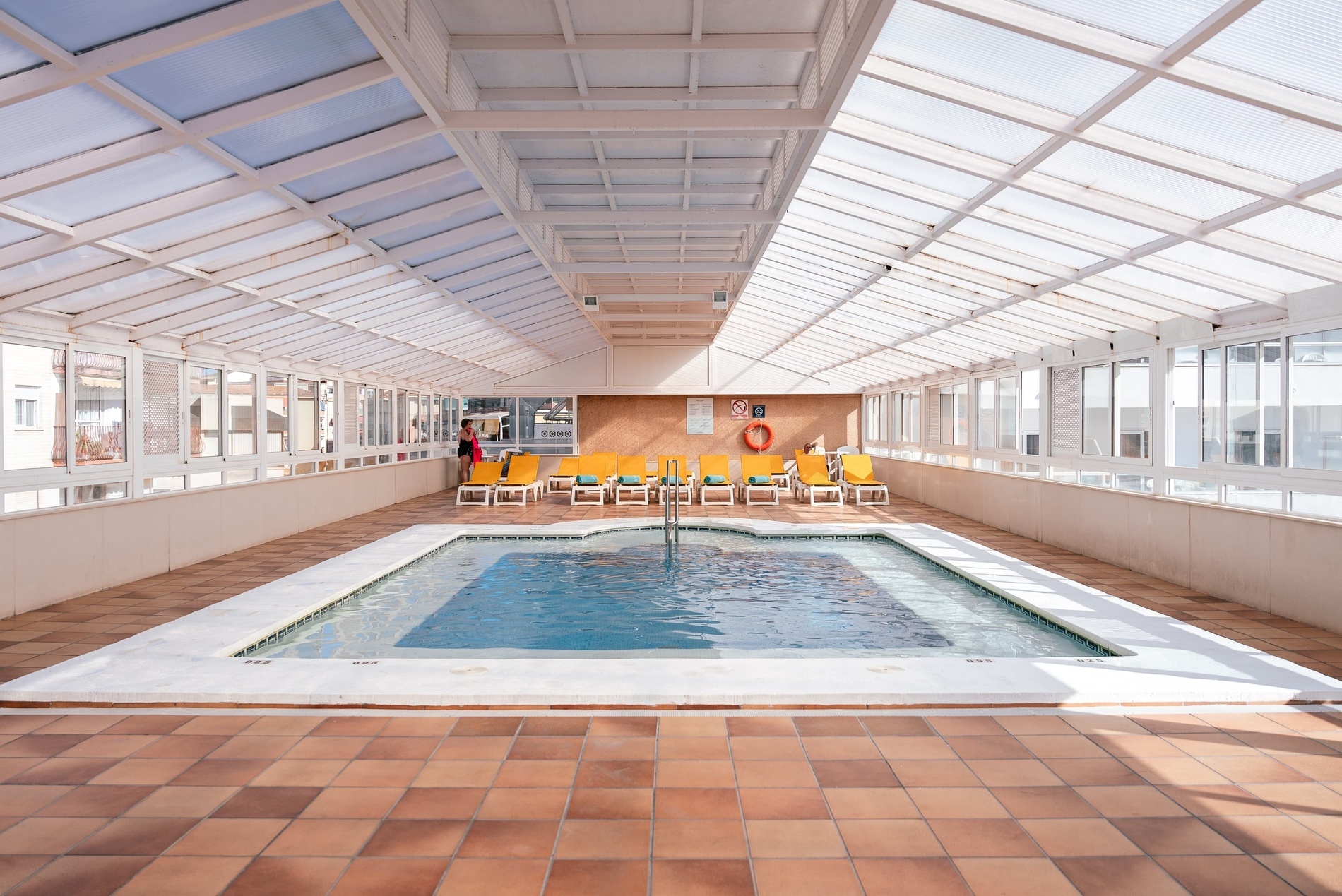 una piscina dentro de un edificio cubierto de vidrio