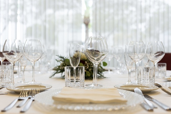 a table with a white table cloth and a bunch of wine glasses on it