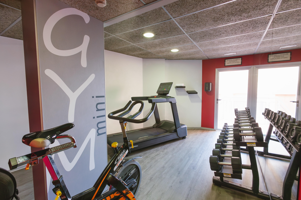 un gimnasio con mancuernas y una cinta de correr