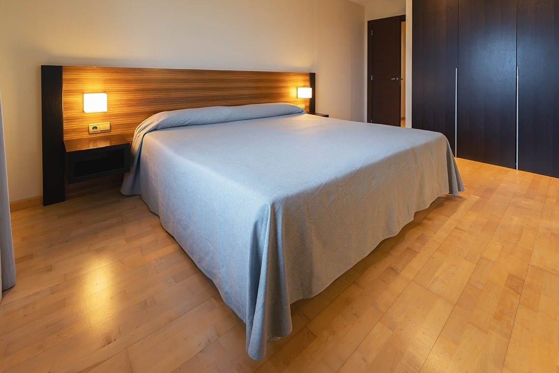 una habitación con una cama y un piso de madera
