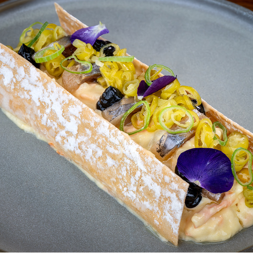 un plato de comida con una flor morada encima