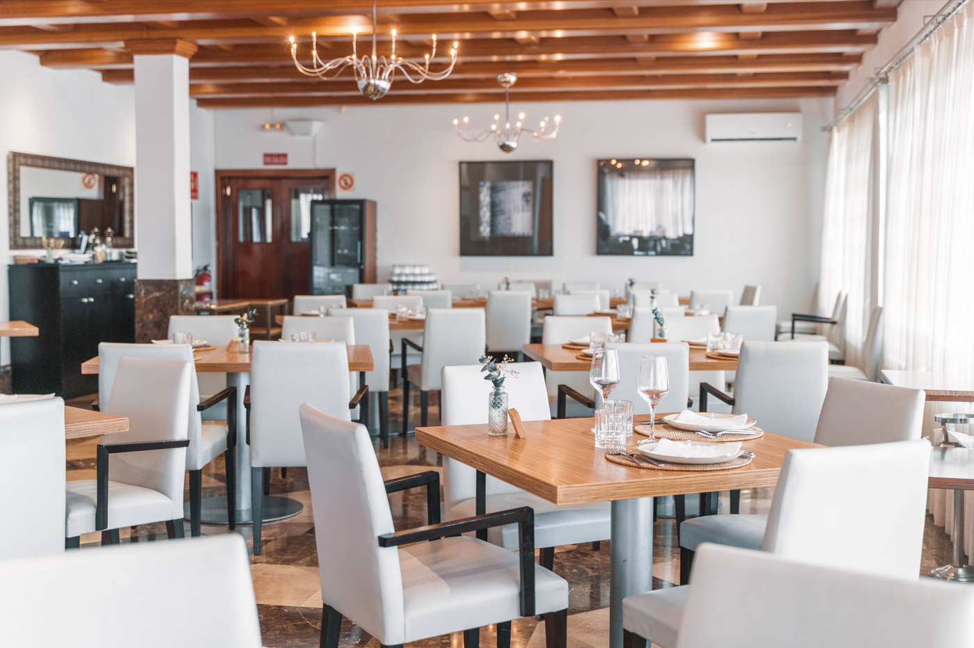 un restaurante lleno de mesas y sillas con un suelo de mármol