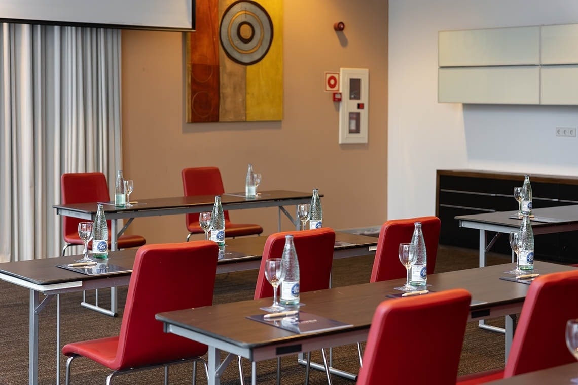 a conference room with tables and chairs and bottles of aquafina water