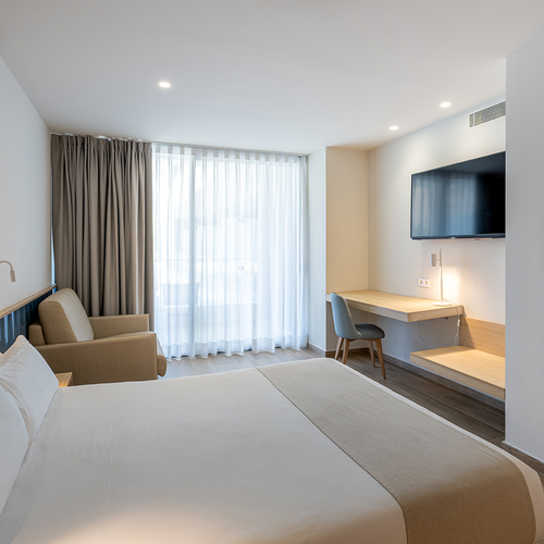 una habitación de hotel con una cama y una televisión