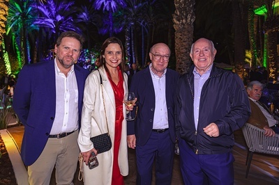 a group of people posing for a picture with a woman holding a glass of wine - 