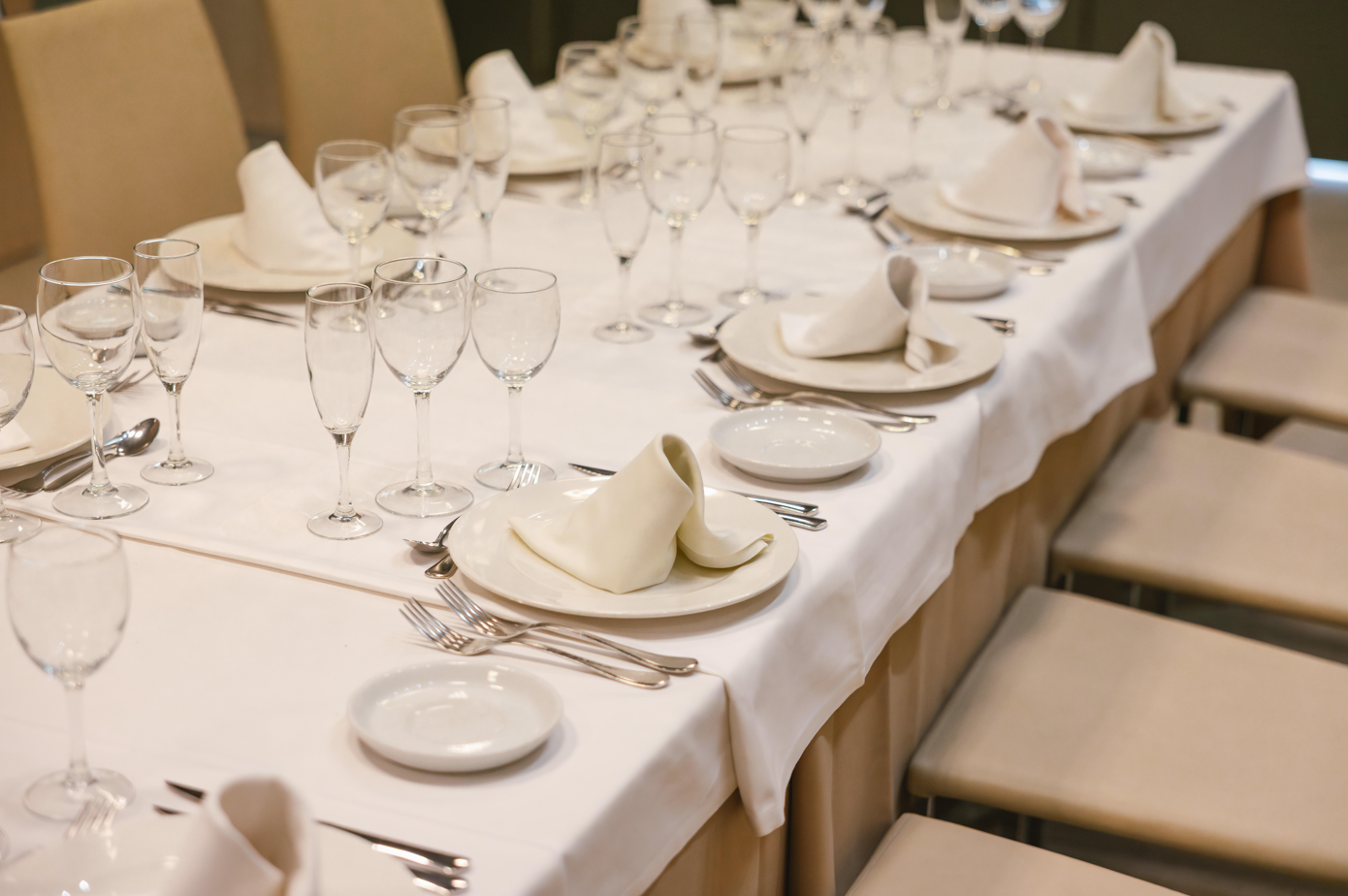 una mesa larga con platos y copas de vino
