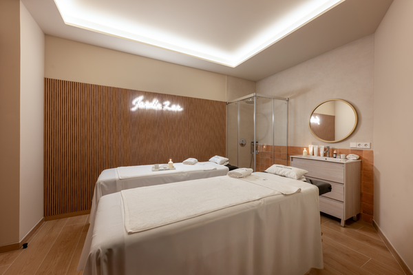 una mujer está dando un masaje a una persona con una botella de aceite