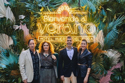 four people pose in front of a sign that says bienvenido al verano - 