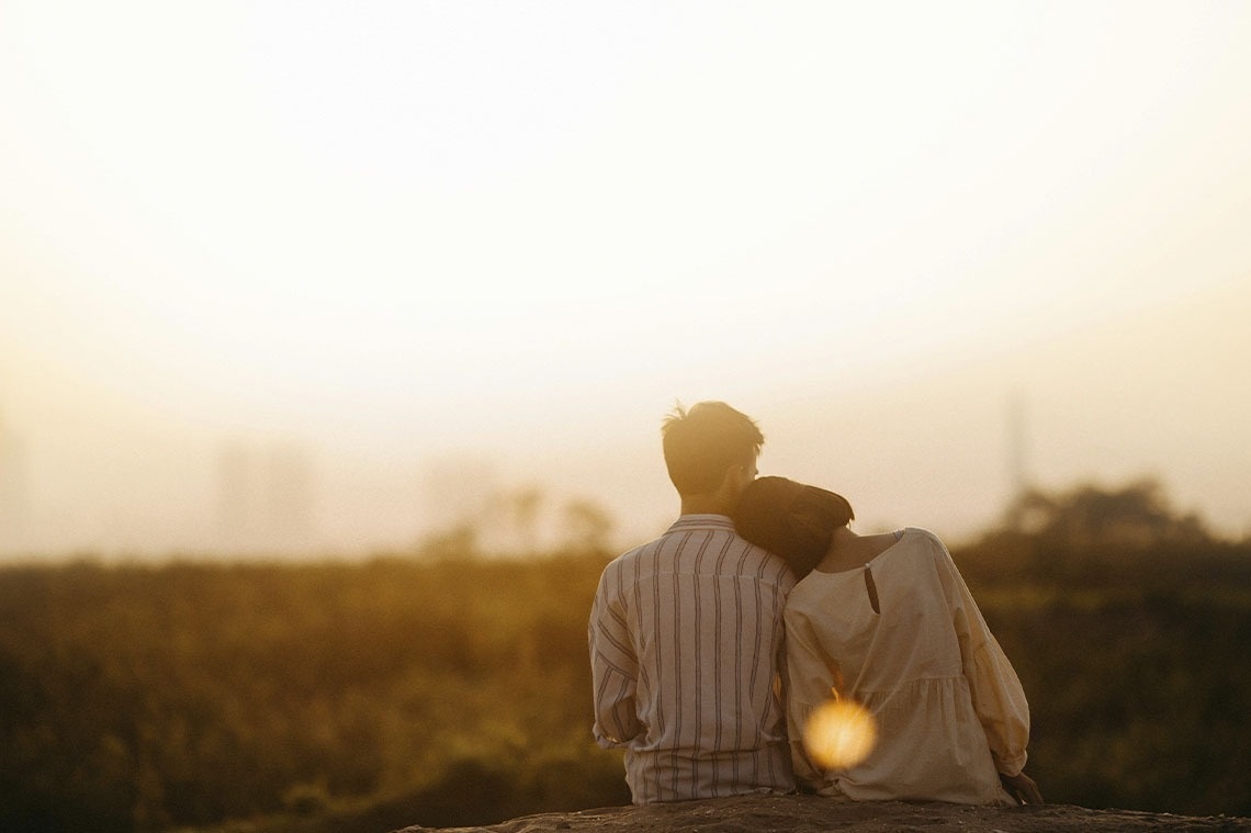 un hombre y una mujer miran la puesta de sol