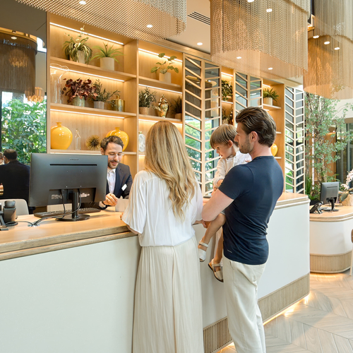 un hombre y una mujer están en la recepción de un hotel