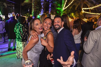 un hombre y dos mujeres posan para una foto en una fiesta - 