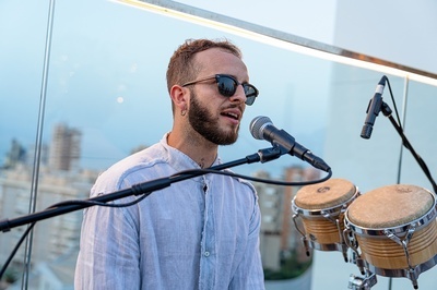 a man singing into a microphone while wearing sunglasses - 