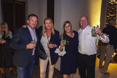 a group of people posing for a picture while holding drinks - 