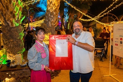 un hombre y una mujer sostienen una bolsa roja que dice feliz navidad - 