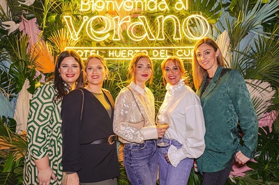 a group of women standing in front of a sign that says verano - 