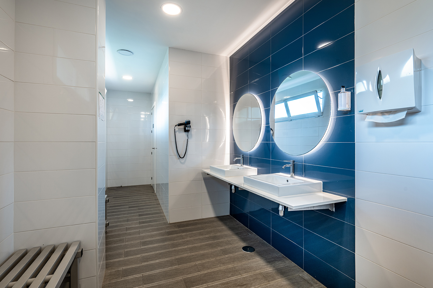 un baño azul y blanco con dos lavabos y dos espejos