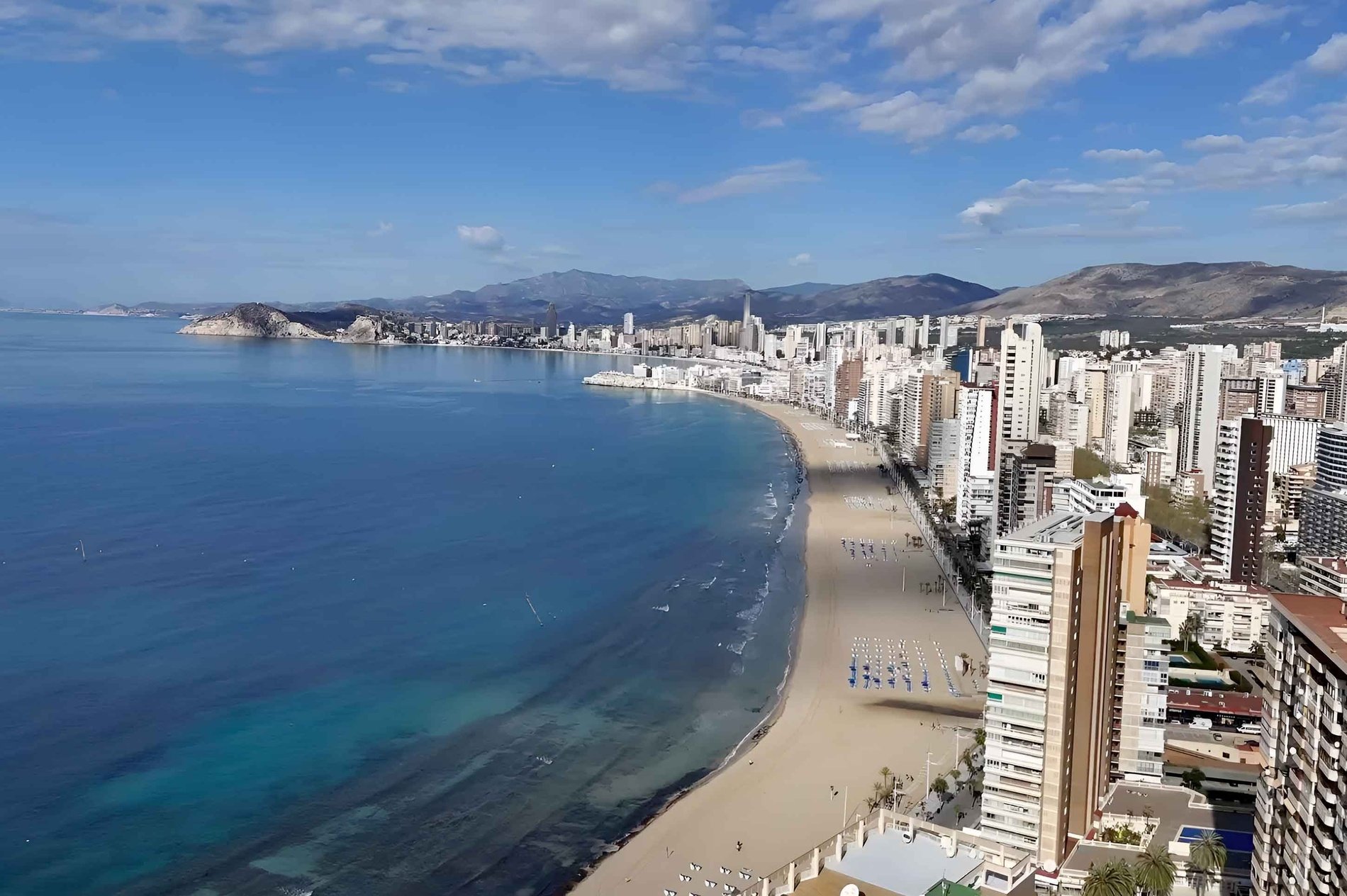 un grupo de personas se divierten en una piscina rodeada de edificios