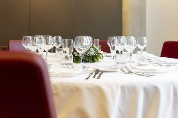 a table with a white table cloth and a bunch of wine glasses on it