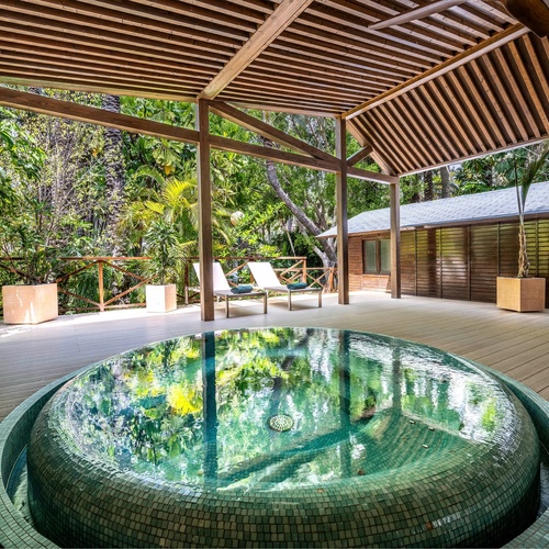 a hot tub with a reflection of trees in it