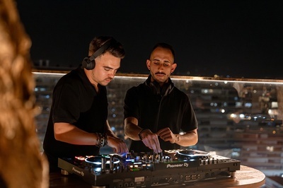 two men are playing music on a pioneer dj mixer - 