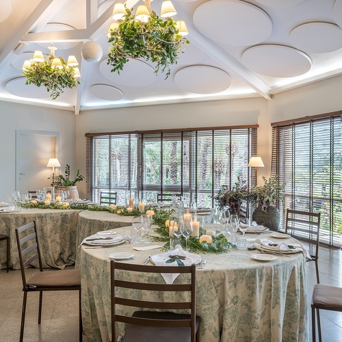 a dining room with tables and chairs and a chandelier hanging from the ceiling