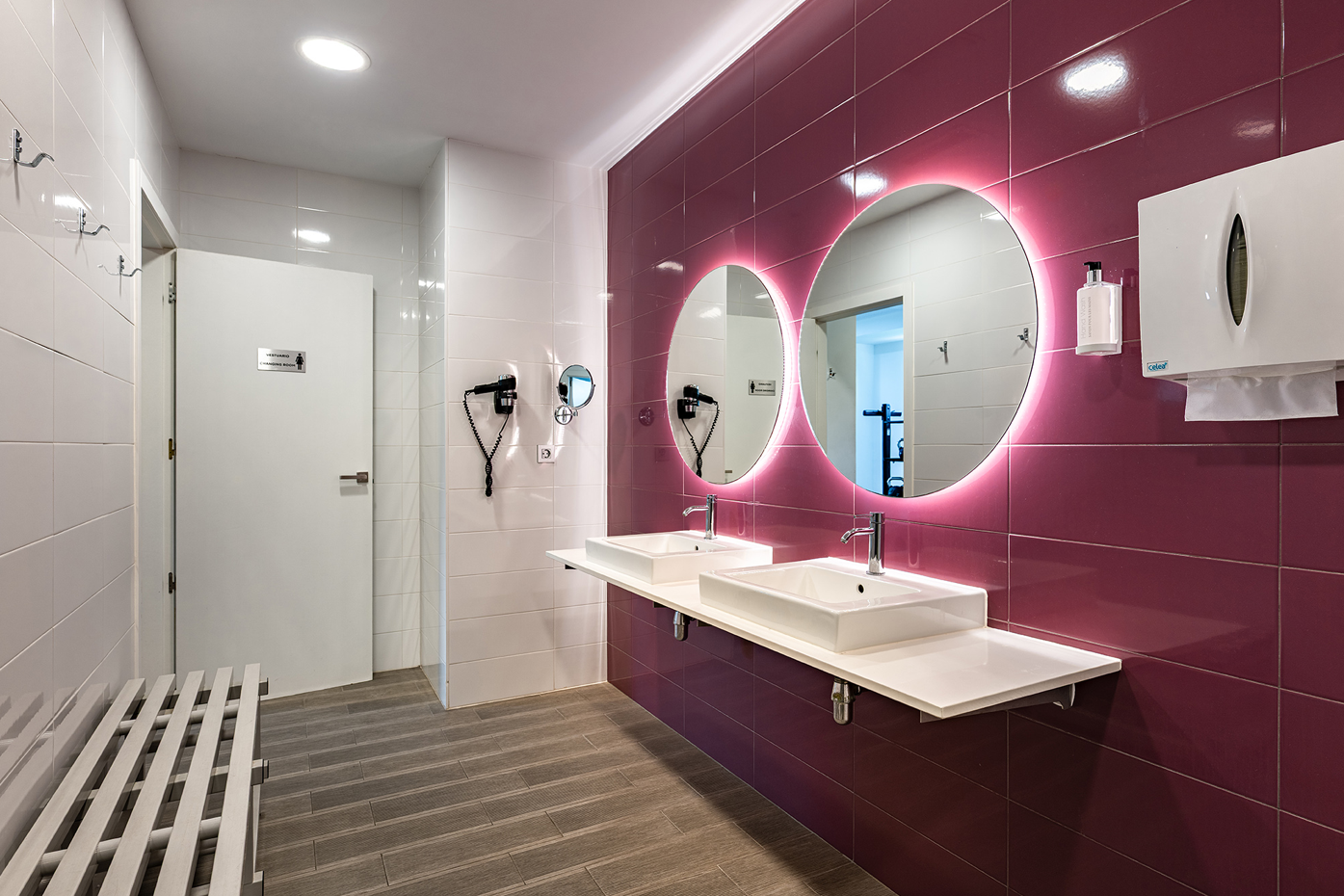 un baño con paredes moradas y lavabos blancos