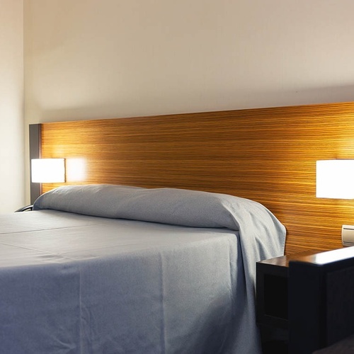 una habitación de hotel con una cama y dos lámparas