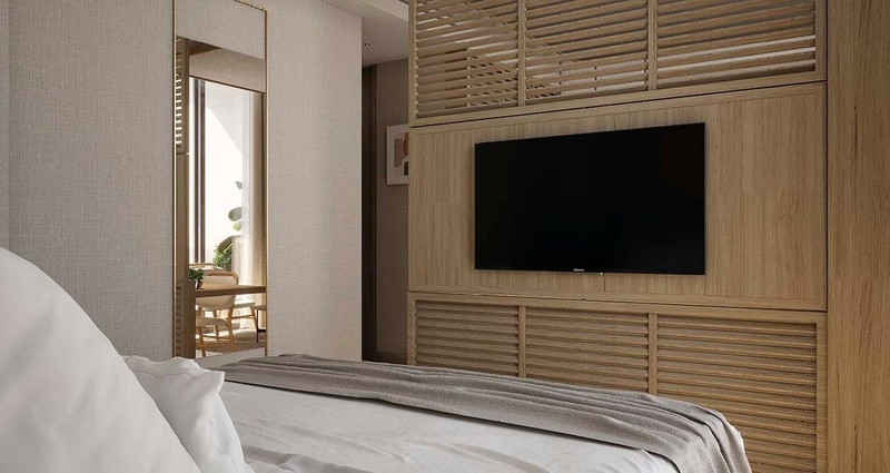 un dormitorio con una cama y una televisión en la pared