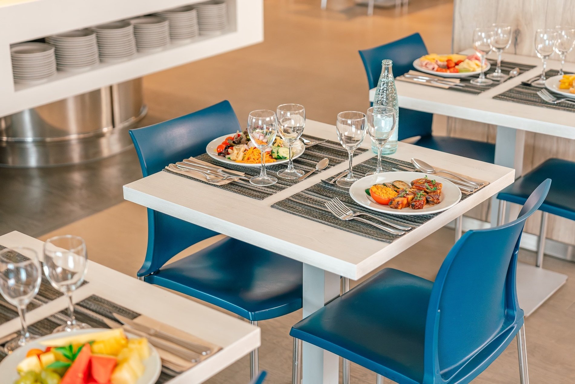 a restaurant setting with plates of food and wine glasses