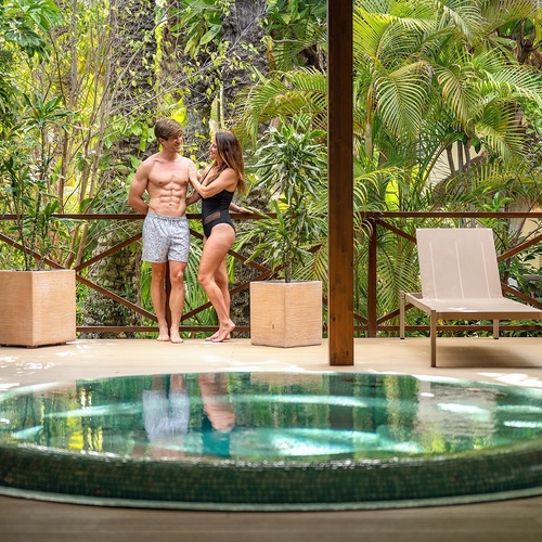 a man and a woman standing next to a hot tub