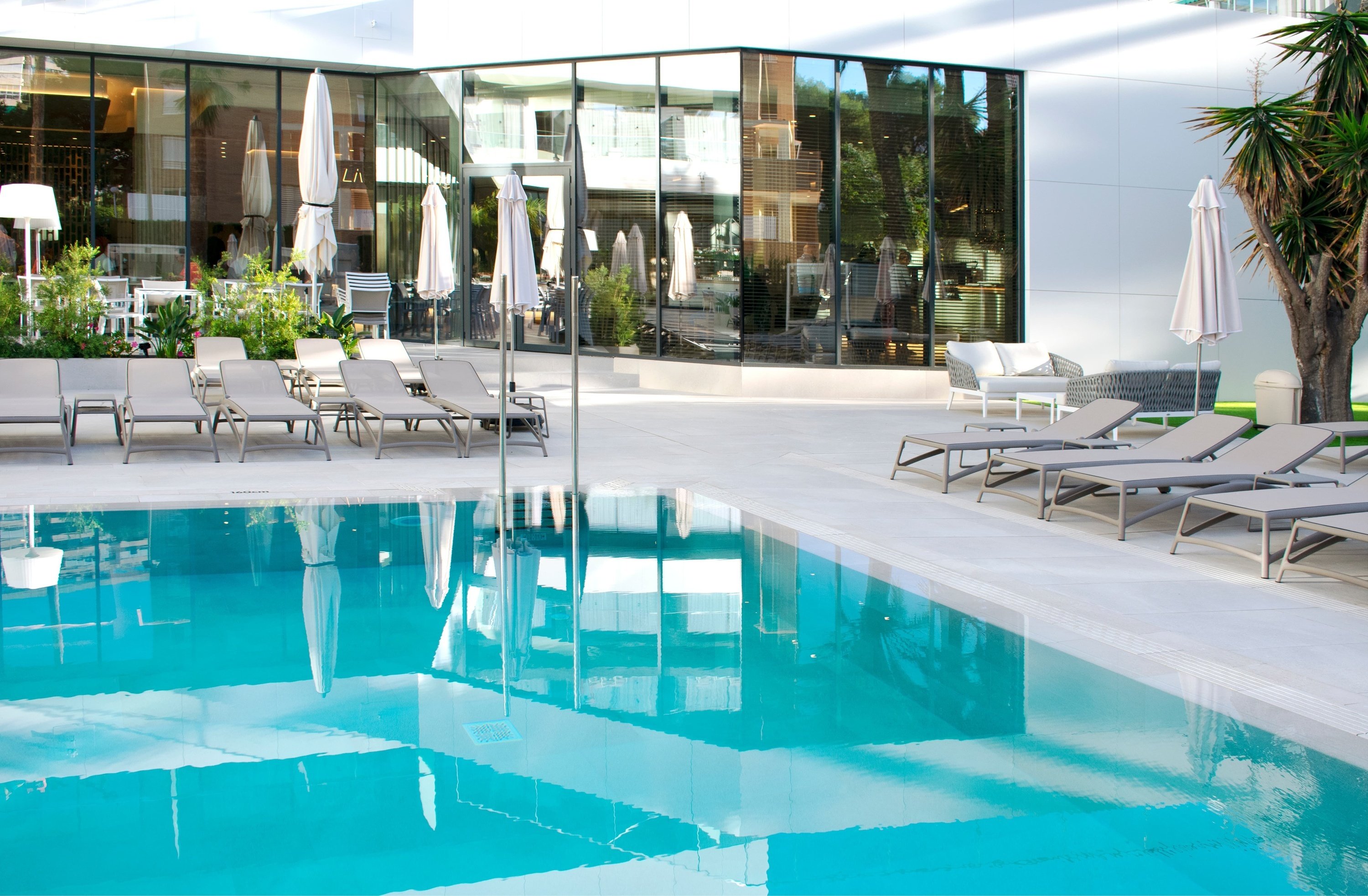 a swimming pool surrounded by lounge chairs and umbrellas