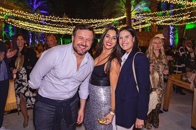a man and two women pose for a picture at a party - 
