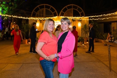 dos mujeres se paran una al lado de la otra en una fiesta - 