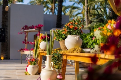un montón de jarrones llenos de flores están sobre una mesa de madera - 
