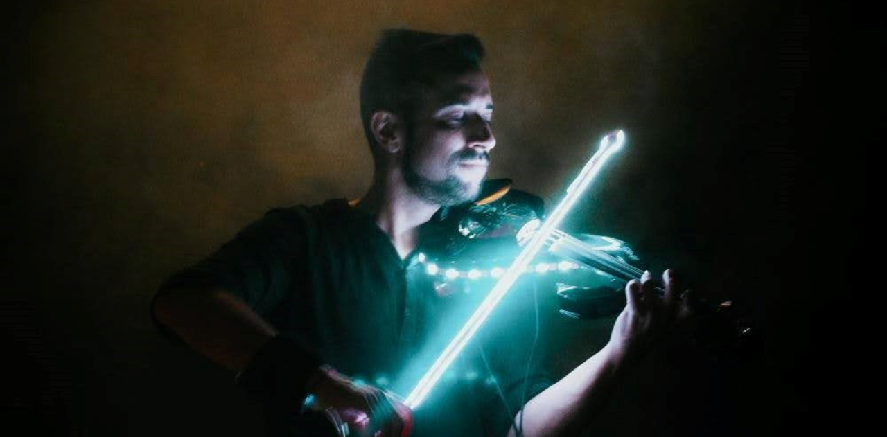 un hombre está tocando un violín con luces de neón .