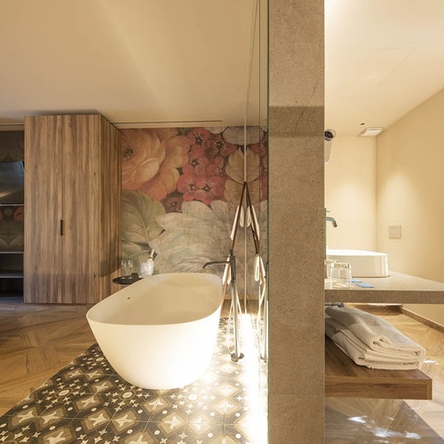 a bathroom with a bathtub and a floral wallpaper on the wall