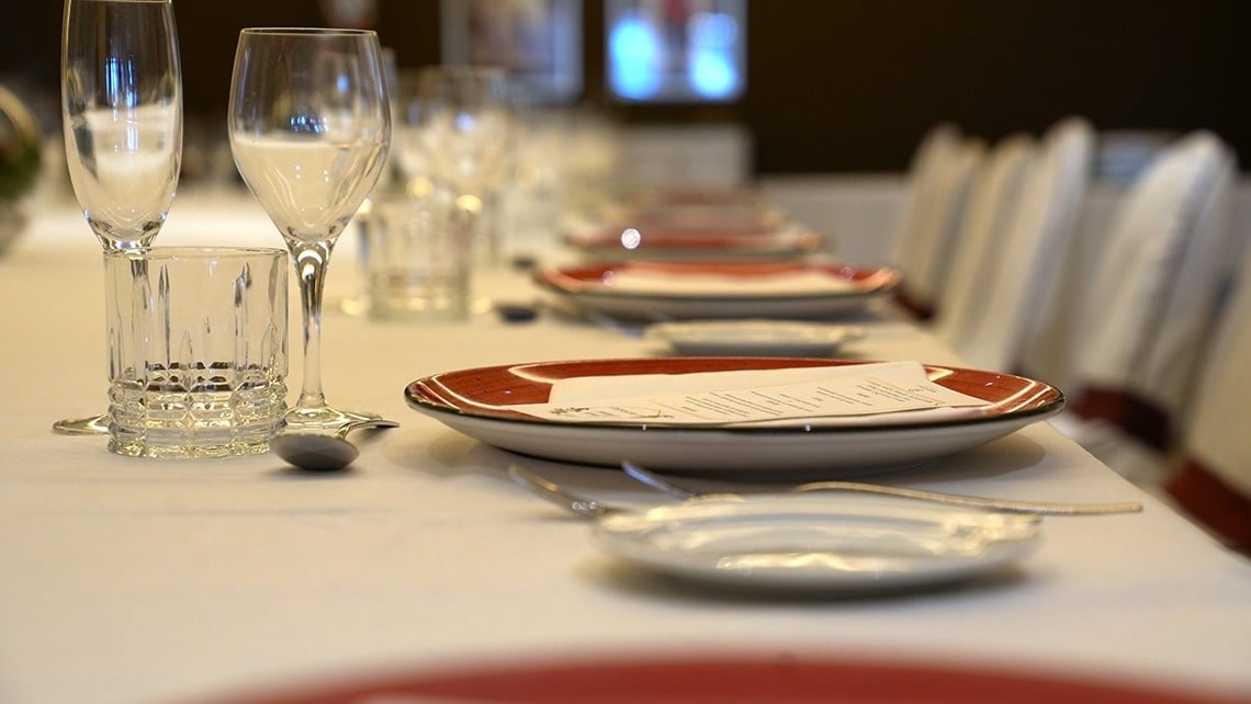 a long table with plates glasses and a menu on it