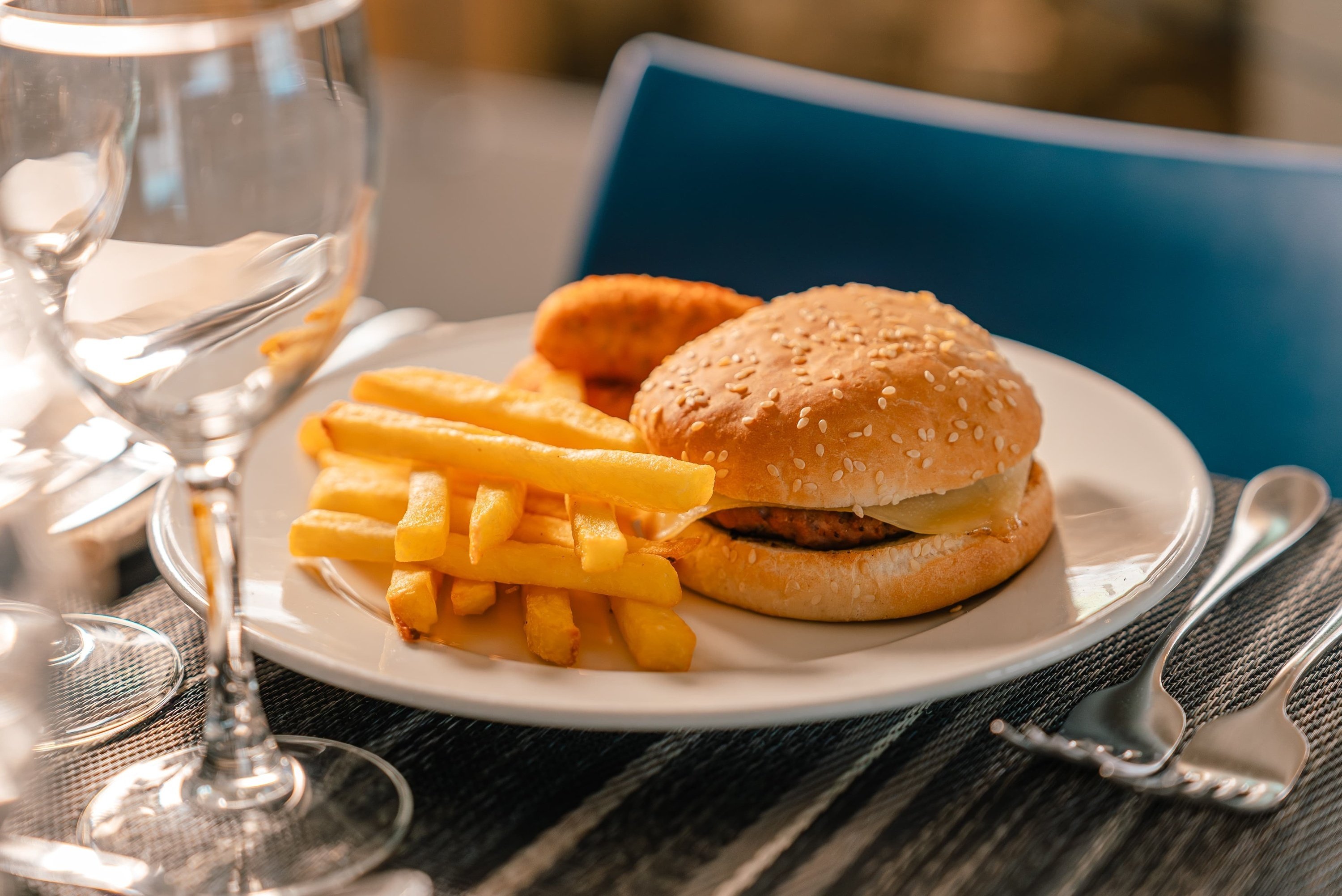 un plato blanco con una hamburguesa y papas fritas