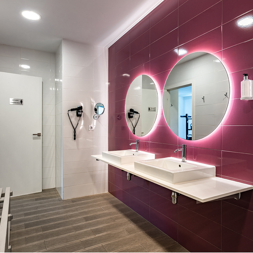 un baño con paredes moradas y lavabos blancos