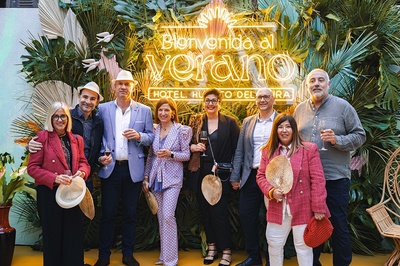 a group of people standing in front of a sign that says bienvenido al verano - 