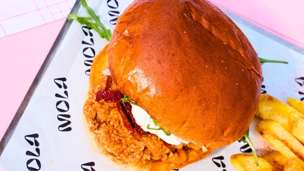 una hamburguesa y papas fritas están envueltos en papel mola