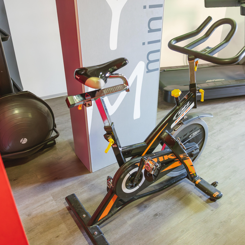 an exercise bike sits in front of a sign that says mini