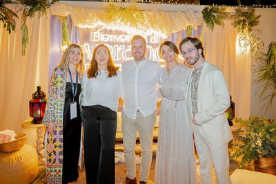 un grupo de personas posando para una foto frente a un cartel que dice bienvenida al verano - 