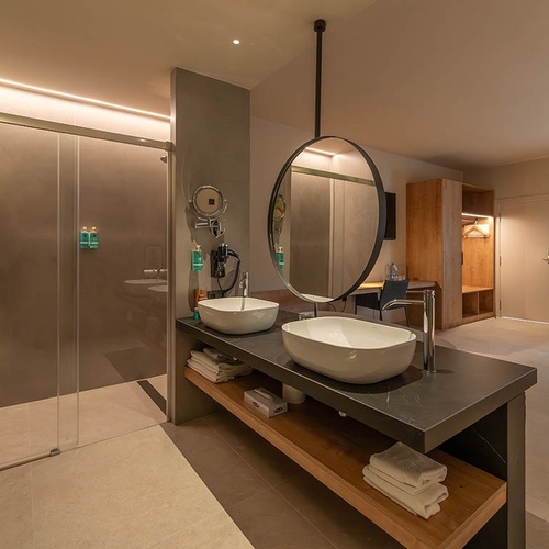 un baño de hotel con dos lavabos y un espejo