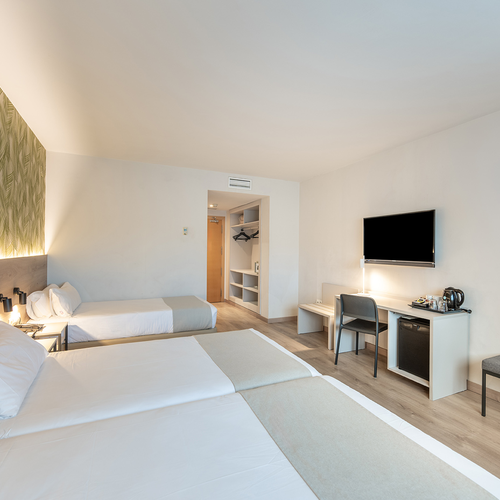 una habitación de hotel con dos camas y una televisión