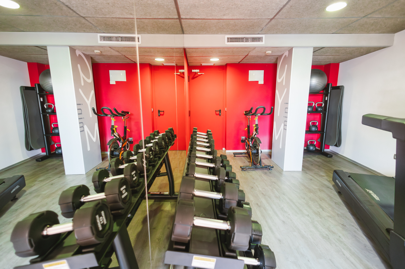 un gimnasio con pesas y una cinta de correr