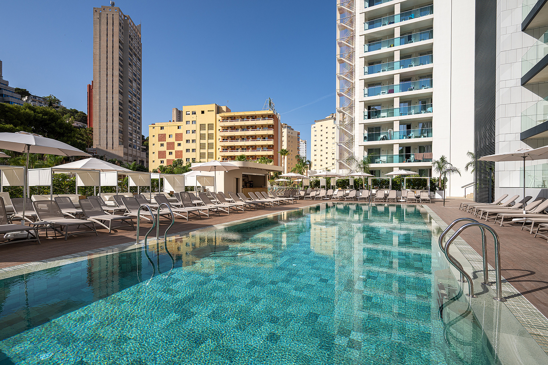 Piscina con tumbonas y vistas a edificios modernos, ideal para Port Benidorm Hotel & Spa | Alicante | Port Hotels | Web oficial.