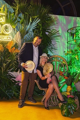 a man and woman pose in front of a sign that says 10 cura - 